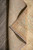 Folded corner revealing tight hand-knotted back, cotton foundation and undyed ivory fringe on tile floor