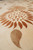 Angled close-up of rust sunflower and gold paisley leaf highlighting silk against wool texture