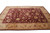 Wine red field and tan border seen from the corner of this handmade wool rug