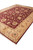 10 x 14 hand-knotted wool rug shown diagonally with burgundy field and cream fringe