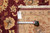 Back tag and tape measure confirming the 10 x 14 foot hand-knotted rug size