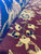 Side angle close-up showing plush pile depth, silk sheen and crisp outlines on burgundy ground