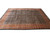 Hand-knotted Oriental rug photographed at an angle showing rust border, ivory fringe and dense navy field