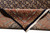 Folded corner revealing wool pile depth, navy selvage, cotton fringe and multi-band rust paisley border
