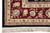 Border corner detail with ivory guard stripe, rose palmettes and green leaves on burgundy ground