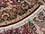 Close-up of ivory guard border, black main border and knotted fringe along the round edge