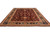 Angled full-length photo showing the wine red field and indigo border of this hand-knotted wool rug