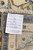 Back tag reading hand-knotted in Pakistan, 100% natural wool, size 13'8 x 9 feet