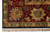 Corner detail of burgundy main border, green guard stripe and clean ivory cotton fringe