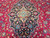 Close detail of cream and turquoise rosette inside the inky navy medallion, hand-knotted wool