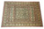 Hand-knotted wool area rug photographed from above, symmetrical Esfahan design with twin green cartouche panels