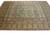 9 x 13 Oriental rug seen at a wide angle with pale green border and blush surround