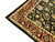 Corner detail of rust border arabesques, ivory guard stripe and dense wool pile on black ground
