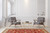 Hand-knotted 9' x 12'5" Kazak rug anchoring a bright living room with grey armchairs and gold table