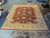 Oversize 12 by 15 wool rug laid flat showing full rust field and gold border