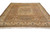 Angled view of beige wool Tabriz rug showing green quatrefoil panel and signature cartouche border
