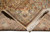 Folded corner showing dense cotton foundation, tight knotting and thick ivory fringe of the rug