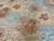 Detail of a rust chrysanthemum and light blue blossom woven in lustrous hand-spun wool