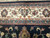 Detail of ivory main border with rose and slate blue palmettes framing the midnight navy field