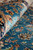 Macro of rolled edge showing silk sheen, teal ground and gold palmette border detail