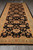 6 x 18 gallery runner laid on grey plank floor showing dark field and gold blossoms