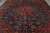 Close angled look at the lobed red medallion and dense navy floral field