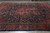 Full overhead view of navy blue antique Persian rug laid out on warehouse floor