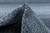 Pinched pile macro showing soft wool texture with charcoal and ivory knots in modern weave