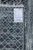 Reverse side with loom tag reading hand knotted in India, design 10105, silver charcoal