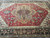 Wide angled shot of geometric medallion rug showing ivory corner spandrels and soft green accents
