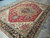 Side angle highlighting deep chocolate border and lustrous wool pile of this Oriental area rug