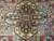 Macro of yellow gold medallion, coral cartouches and teal tracery in hand-knotted wool