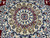 Center medallion close-up with cream rosette core, red teardrops and blue scrolling arabesques