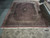 Oversized 11x15 wool rug laid flat on showroom floor showing herati field and wide borders