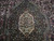 Center medallion close-up in ivory and olive over near-black navy hand-knotted wool pile