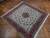 Angled floor view showing ivory field, coral border and dense wool and silk knotting