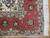 Corner detail of coral border, taupe guard stripe, palmettes and clean ivory cotton fringe