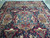 Large 10x13 Persian rug viewed lengthwise with medallion, cartouches and ivory fringed end visible