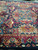 Indigo field with salmon oval cartouche and raspberry main border photographed from one corner