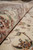 Rolled edge close-up showing dense wool and silk pile depth against the ivory floral ground