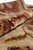 Rolled edge of the rug showing silk highlights catching light along the border