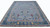 10x14 hand-knotted Indian Oushak rug angled on white, showing blue field and navy border