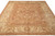 Angled floor view showing rust brown field, ivory palmette border and soft wool sheen