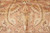 Large curved leaf cartouche in gold and cream drawn across the soft rust wool field