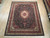 8x10 wool and silk Tabriz design rug laid flat on pale wood floor in showroom