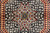 Macro view of the black medallion interior with ivory sprigs and a teal green star