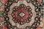 Close-up of an octagonal corner medallion in red, black and silver with 8 petal rosette