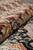 Rolled edge of the 9 by 12 wool rug revealing supple handle and vivid dye tones
