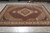 Large area rug photographed on a warehouse floor showing the full Mahi Tabriz medallion and corner design