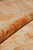 Rolled edge close-up showing plush natural wool pile depth in gold and rust tones